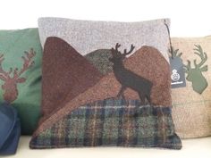 three pillows with deer and moose designs on them