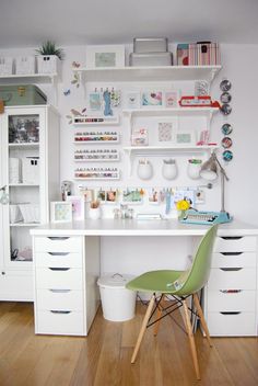 a white desk topped with lots of drawers next to a shelf filled with books and other items