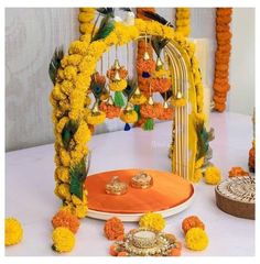 an orange and white table with yellow flowers, candles and other decorations on top of it