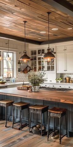 a kitchen with an island and stools in the center, surrounded by wooden flooring