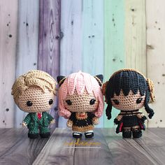 three little dolls sitting on top of a wooden table