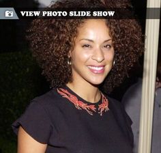 a woman with curly hair smiling at the camera