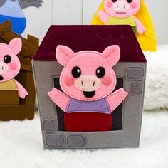 three little pigs sitting on top of a white blanket next to each other and one is wearing a pink shirt