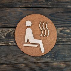 a wooden sign with a man sitting on a chair and steam coming out of his mouth