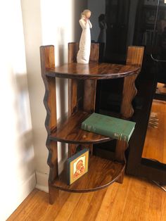 a wooden shelf sitting on top of a hard wood floor next to a book case