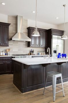 a kitchen with dark cabinets and white counter tops