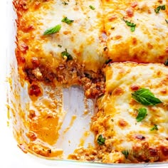 lasagna casserole with meat and cheese in a glass dish on a white surface