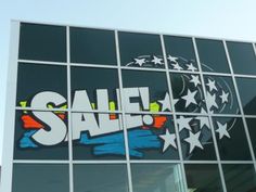 a large window with the word sale painted on it's side in front of a building