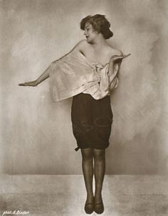 an old black and white photo of a woman with her arms outstretched