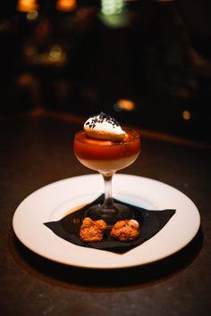 a dessert on a white plate sitting on a black table top with other food items