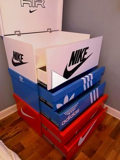 several nike boxes stacked on top of each other in a room with wood flooring