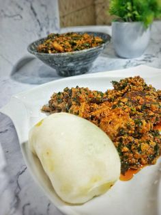 some food is sitting on a white plate and next to a bowl of sauces