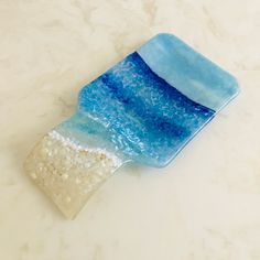 a blue and white glass dish sitting on top of a marble counter next to a sink