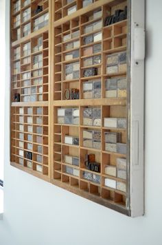 a wooden wall with lots of different types of tiles on it and a window in the background