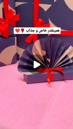 an open gift box with a fan on it and two wrapped presents in the background