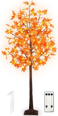 a lighted tree with orange leaves on it and remote controls in front of white background