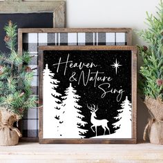 a wooden frame sitting on top of a shelf next to christmas trees and pine cones