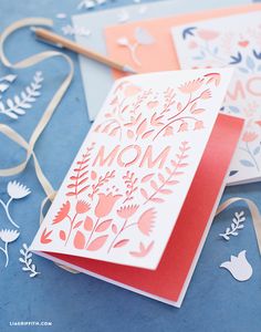 two cards with the word mom on them and some paper cut outs next to it