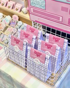 some pink and blue bags are in a basket on the table next to other items