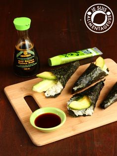 sushi on a cutting board with dipping sauce