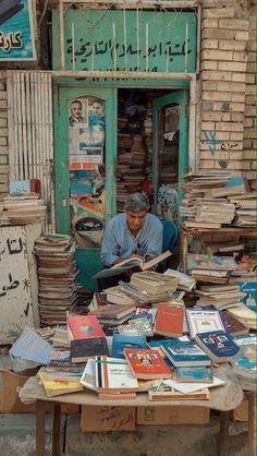 a man sitting at a table filled with books