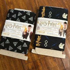 two harry potter notebooks sitting on top of a wooden table