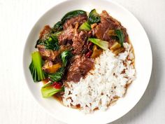 a white plate topped with rice and meat