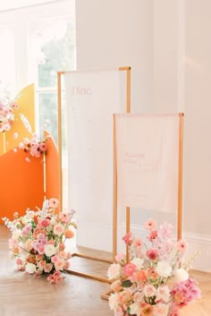 flowers in vases are sitting on the floor next to an easel and sign