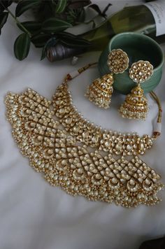 The majestically handcrafted kundan necklace set is an ode to the Indian tradition and intricate work handcrafted by the artisans. The bridal necklace embedded with high grade kundan and shell pearls hanging is a masterpiece inspired by Sabyasachi jewelry. The kundan jhumka earrings paired with the necklace are perfect for all the beautiful brides-to-be!  Pair this replica of an ancestral jewelry necklace set with your traditional ensembles and create a look to remember.  Necklace Closure - Adju Luxury Bridal Necklace With Intricate Design For Diwali, Luxury Bridal Necklace With Latkans For Reception, Luxury Bridal Chandbali Necklace With Stone Work, Luxury Ceremonial Bridal Necklace With Zari Work, Luxury Intricate Bridal Necklace For Puja, Traditional Temple Necklace With Gota Work For Celebration, Traditional Festive Jewelry With Gota Work, Traditional Bridal Necklace With Gota Work For Celebration, Traditional Jewelry Sets With Gota Work For Celebration