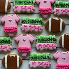 decorated cookies with pink, green and brown icing on a wooden table next to each other