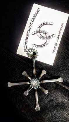 a black leather jacket with a silver cross brooch