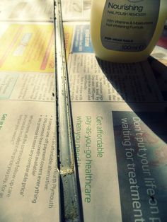 a bottle of nourishing sitting on top of newspaper next to a ruler