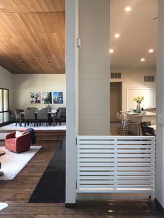 a living room filled with furniture next to a kitchen and dining room table on top of a hard wood floor