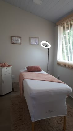 a bed sitting in a bedroom next to a window with blinds on the windowsill