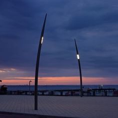 two tall metal poles sitting on top of a sidewalk