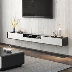 a living room with a large flat screen tv mounted on the wall next to a coffee table