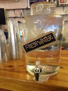 a glass jar filled with water sitting on top of a wooden counter