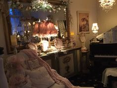 a living room filled with furniture next to a piano and chandelier covered in lights