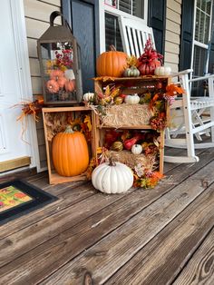 pumpkins, hay bales and other decorations sit on the front porch