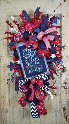 a red, white and blue wreath on a door with the words happy fourth of july written on it