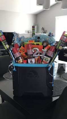 a cooler filled with lots of assorted items sitting on top of a black table