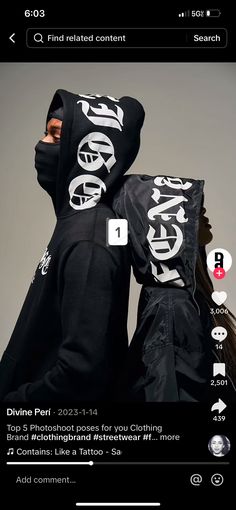 two people wearing black hoodies with white letters on them