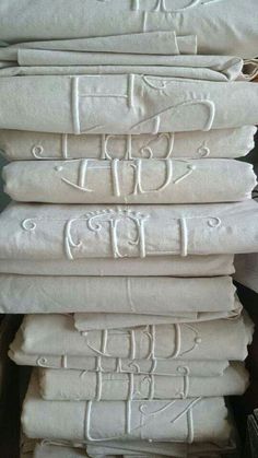 towels stacked on top of each other with the letters e and f in white ink