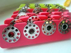 there are many different types of beads on this pink holder with holes in the middle