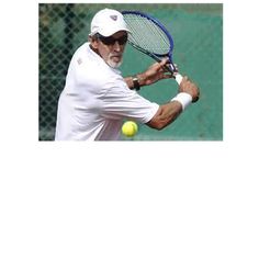 an old man swinging a tennis racket at a ball