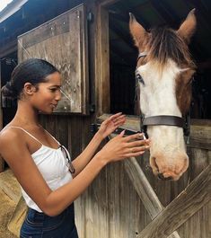 a woman is petting the nose of a horse