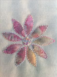 a close up of a piece of cloth with beads on it and a flower in the middle