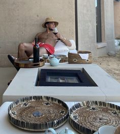 a man sitting on top of a white table next to plates and bowls with food