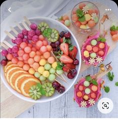 there are many different fruits in the bowl and on the table next to each other