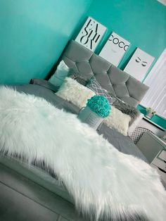 a bedroom with blue walls and white fur on the bed